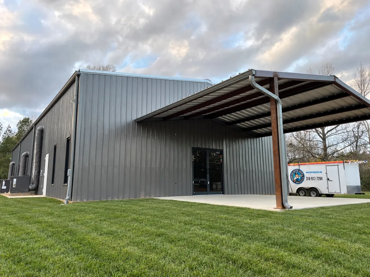 Commercial metal building with a covered awning, the company trailer parked alongside