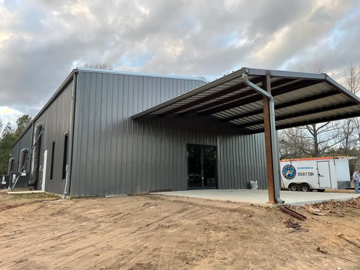 Commercial metal building with a covered awning, the company trailer parked alongside