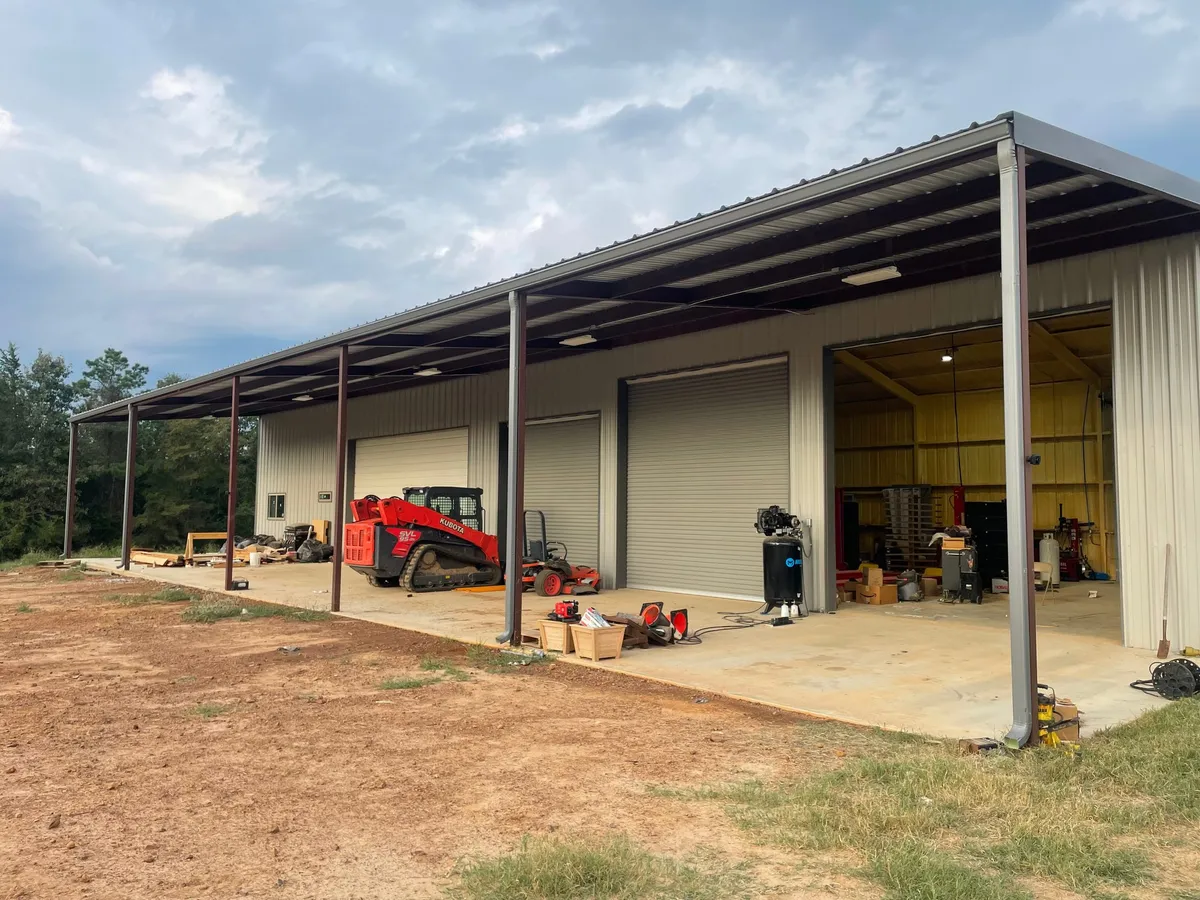 Commercial metal building with a long covered bay and equipment inside