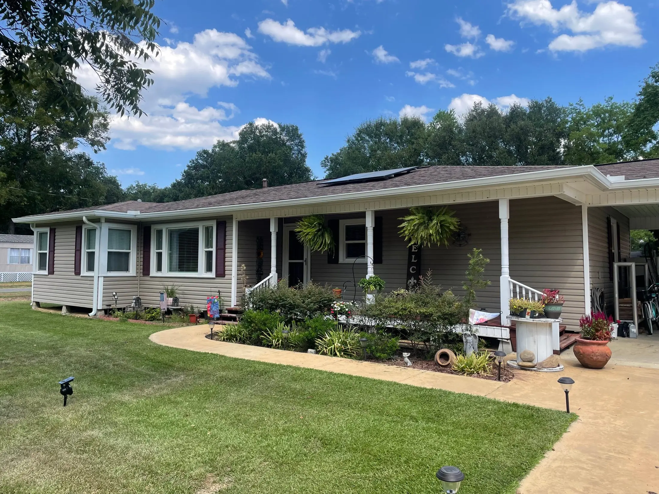 Long single-story home with a covered porch and white gutters