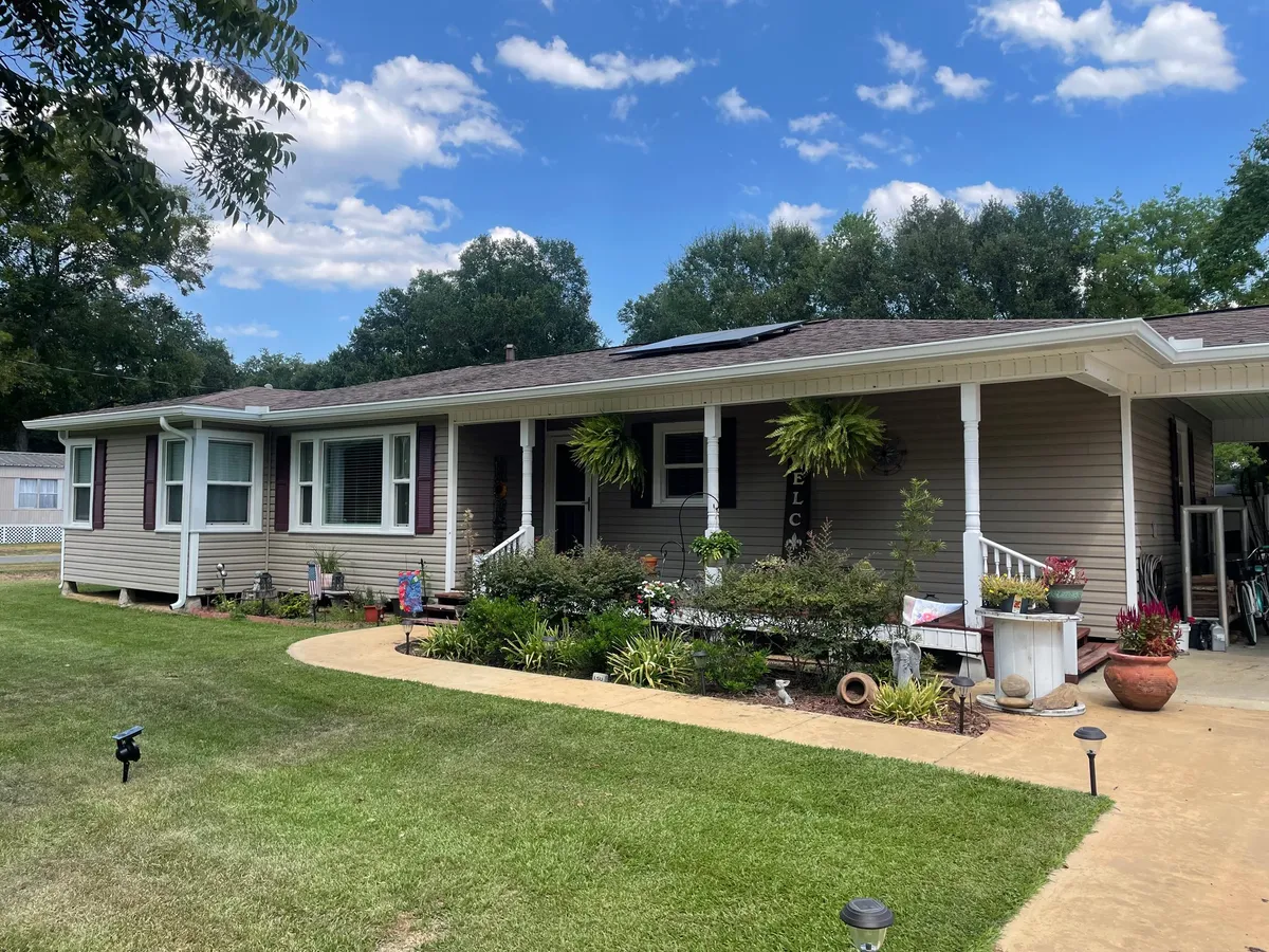 Long single-story home with a covered porch and white gutters
