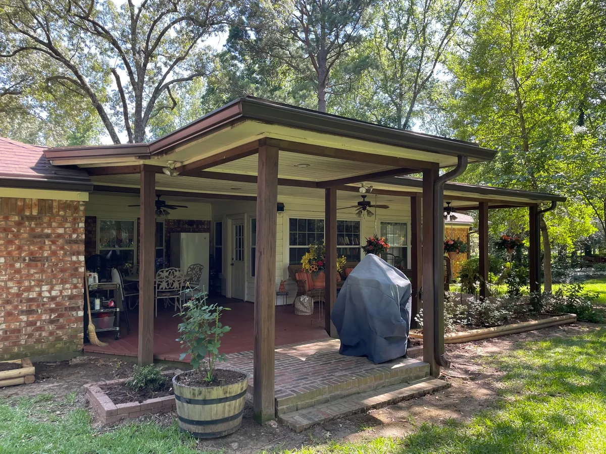 Brick home with a wooden covered patio structure
